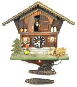 A 20th century Cuckoo clock of Swiss Chalet exterior form the doors opening to reveal a cow,