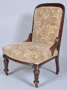 An antique mahogany nursing chair having tall padded backrest and sprung seat upholstered in a