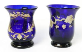 A 19th century blue glass mug painted in enamels and gilt, with loop handle and pontil mark,