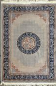 A Chinese cut style carpet with a central medallion on a grey ground within a fretwork border,