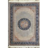 A Chinese cut style carpet with a central medallion on a grey ground within a fretwork border,