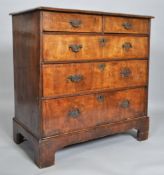 A George III walnut chest of two short and three long drawers, on bracket feet,