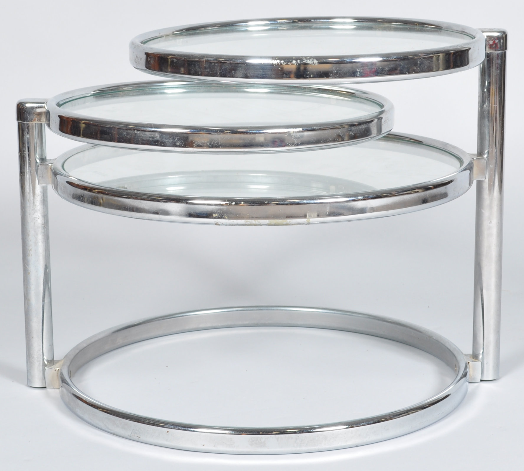 In the manner of Milo Baughman, a retro vintage chrome and glass three tier cocktail table,