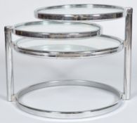 In the manner of Milo Baughman, a retro vintage chrome and glass three tier cocktail table,