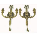 A pair of brass two branch wall lights, in the form of a bow with ribbon issuing two candle sconces,