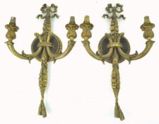 A pair of brass two branch wall lights, in the form of a bow with ribbon issuing two candle sconces,