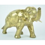 An Oriental polished bronze figure of an elephant with trunk aloft, signature to the underside,
