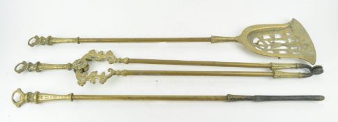 A set of three brass fire irons, each with shaped ring finials,