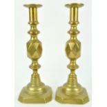 A pair of 'King of diamonds' brass candlesticks, stamped marks,
