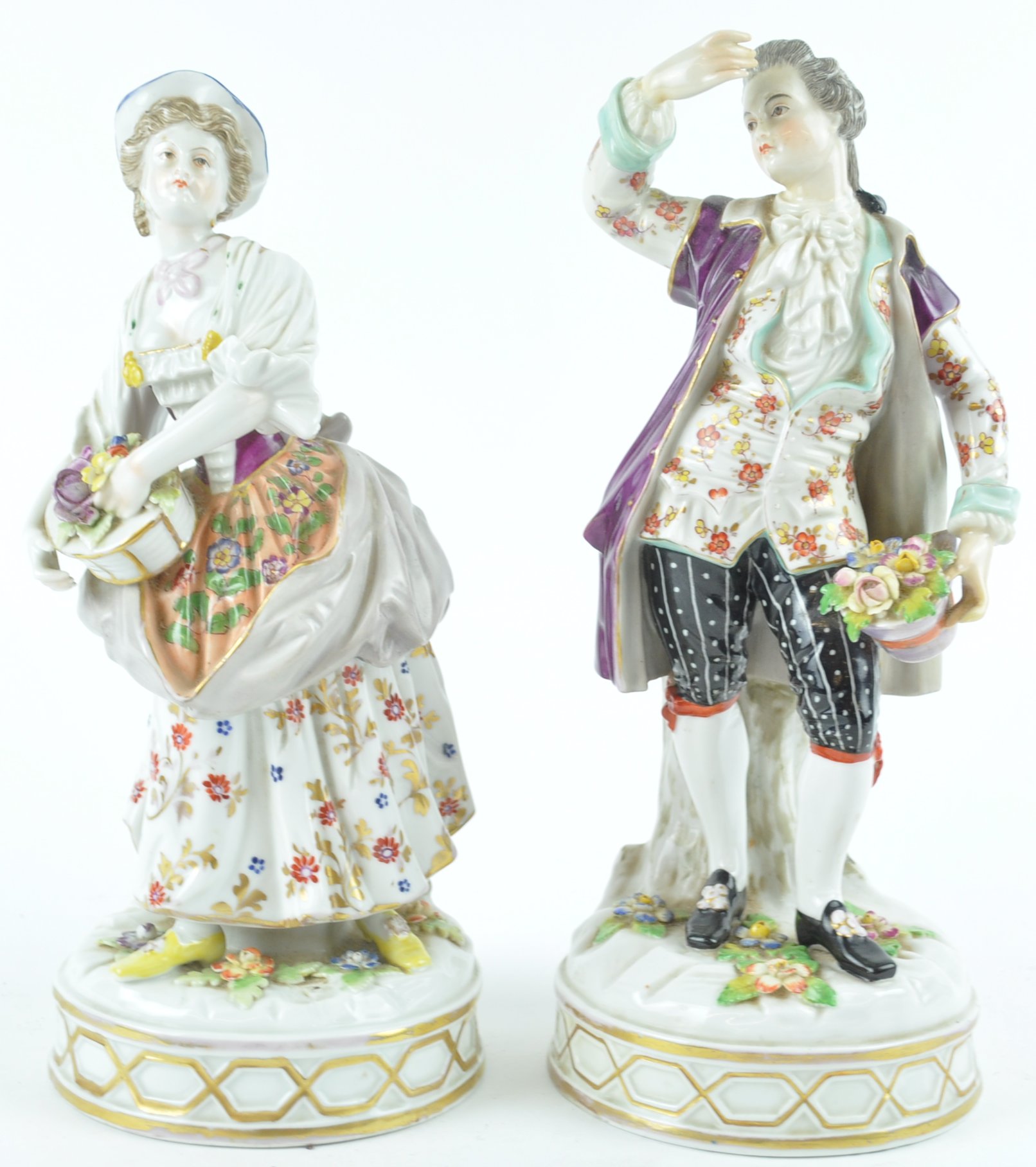 A pair of 19th century Continental porcelain figures of a lady holding a basket of flowers,