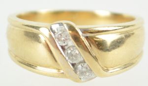 A yellow metal ring. Set with three round brilliant cut diamonds stated to weigh a total of 0.25cts.