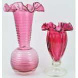 A large cranberry tinted vase with globular body and flared neck, terminating in a wide frill rim,