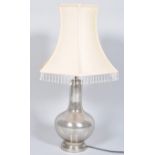 A contemporary glass lamp base having a translucent mottled silver pattern raised on a plinth base,