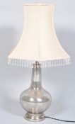 A contemporary glass lamp base having a translucent mottled silver pattern raised on a plinth base,