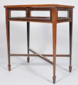 An Edwardian mahogany bijouterie table on squared tapering legs with spade feet,