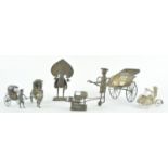 A group of Asian white metal model rickshaws, the largest 9cm high,