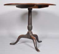 A George III oak tilt top table, on turned baluster support on three cabriole legs,