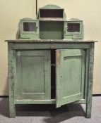 A French green painted dressing table with raised back above two panelled doors and square legs,