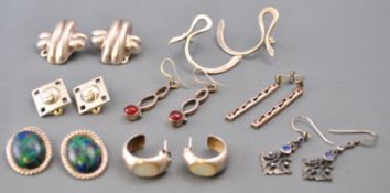 A collection of eight pairs of pierced and clip silver earrings of variable designs.