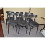 A set of six black chairs with curved back rails