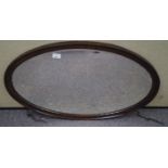 An oval oak framed mirror