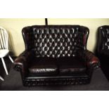 A leather button back two seat sofa