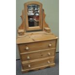 A pine chest of drawers and a mirror