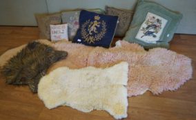 A group of cushions and a sheepskin rug