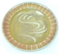 A Studio pottery charger, decorated with brown glazes, impressed monogram J B,