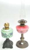 Two coloured glass oil lamps.