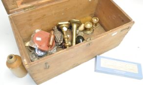 A pine box containing brass candlesticks and other items