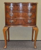 A 20th century serpentine fronted walnut chest on cabriole legs,