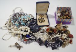 A collection of assorted costume jewellery necklaces and brooches