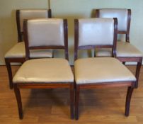 A set of four dining chairs with leatherette seats and backs