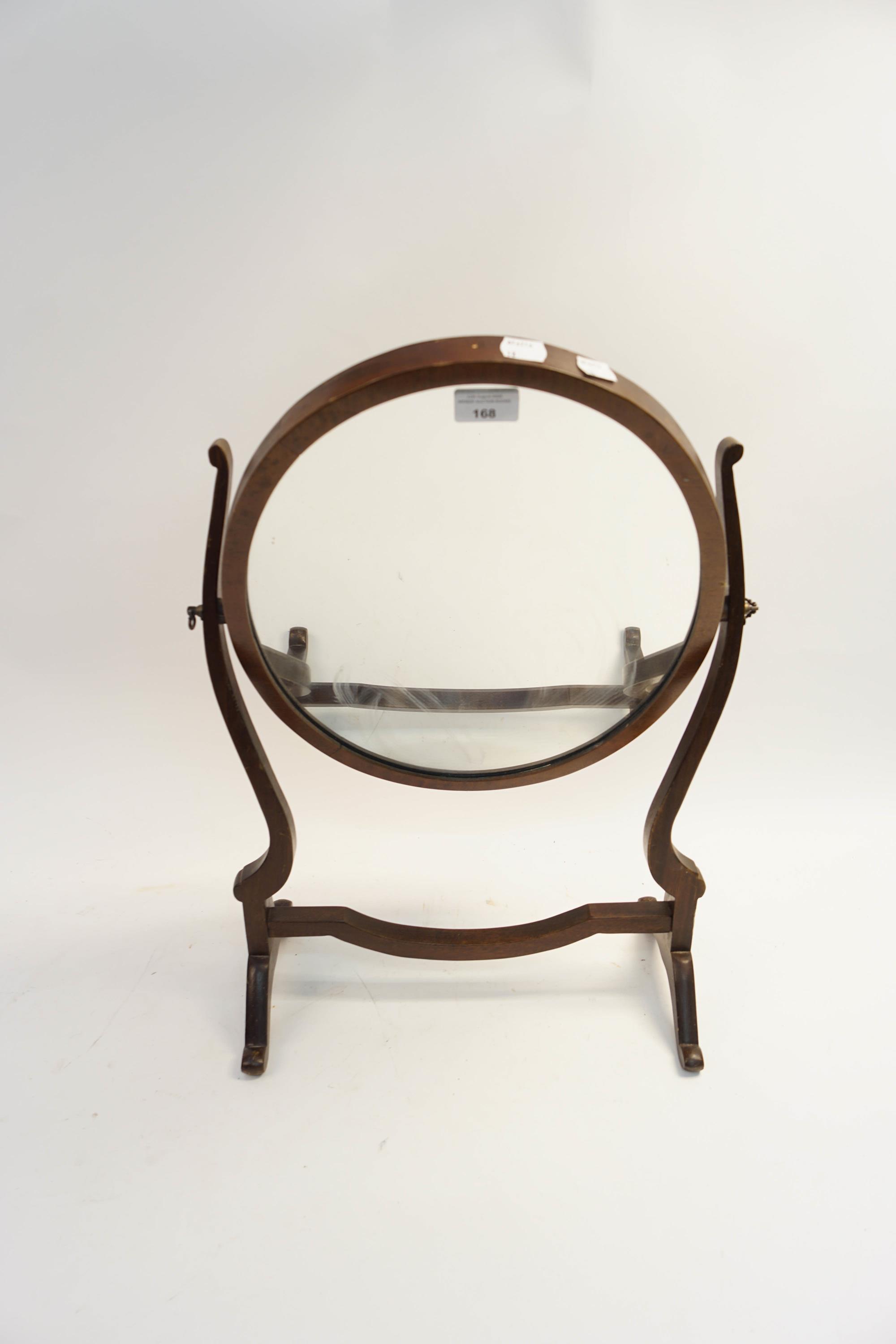 An oval mahogany swing mirror
