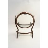 An oval mahogany swing mirror