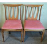 A pair of retro vintage teak wood dining chairs with panel back rests,