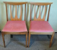 A pair of retro vintage teak wood dining chairs with panel back rests,