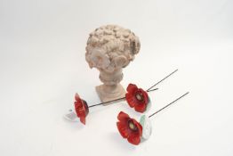 A collection of garden statuary and poppies