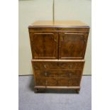 A walnut chest of drawers with two panelled cupboard doors above,