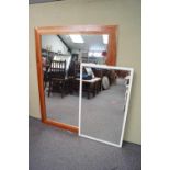 A large pine framed mirror and a white framed mirror,