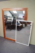 A large pine framed mirror and a white framed mirror,