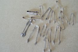 A group of assorted plated sugar tongs