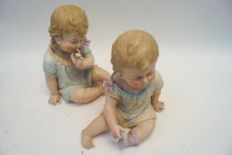 Two bisque porcelain piano babies