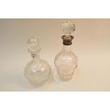 A silver collared cut glass decanter and another