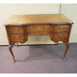 A walnut desk, with shaped front,