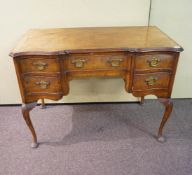 A walnut desk, with shaped front,