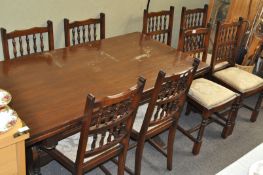 An oak draw leaf refectory table and eight chairs