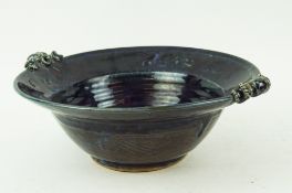 A Studio pottery dark blue glazed stoneware two handled bowl with scroll moulded handle,