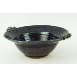 A Studio pottery dark blue glazed stoneware two handled bowl with scroll moulded handle,